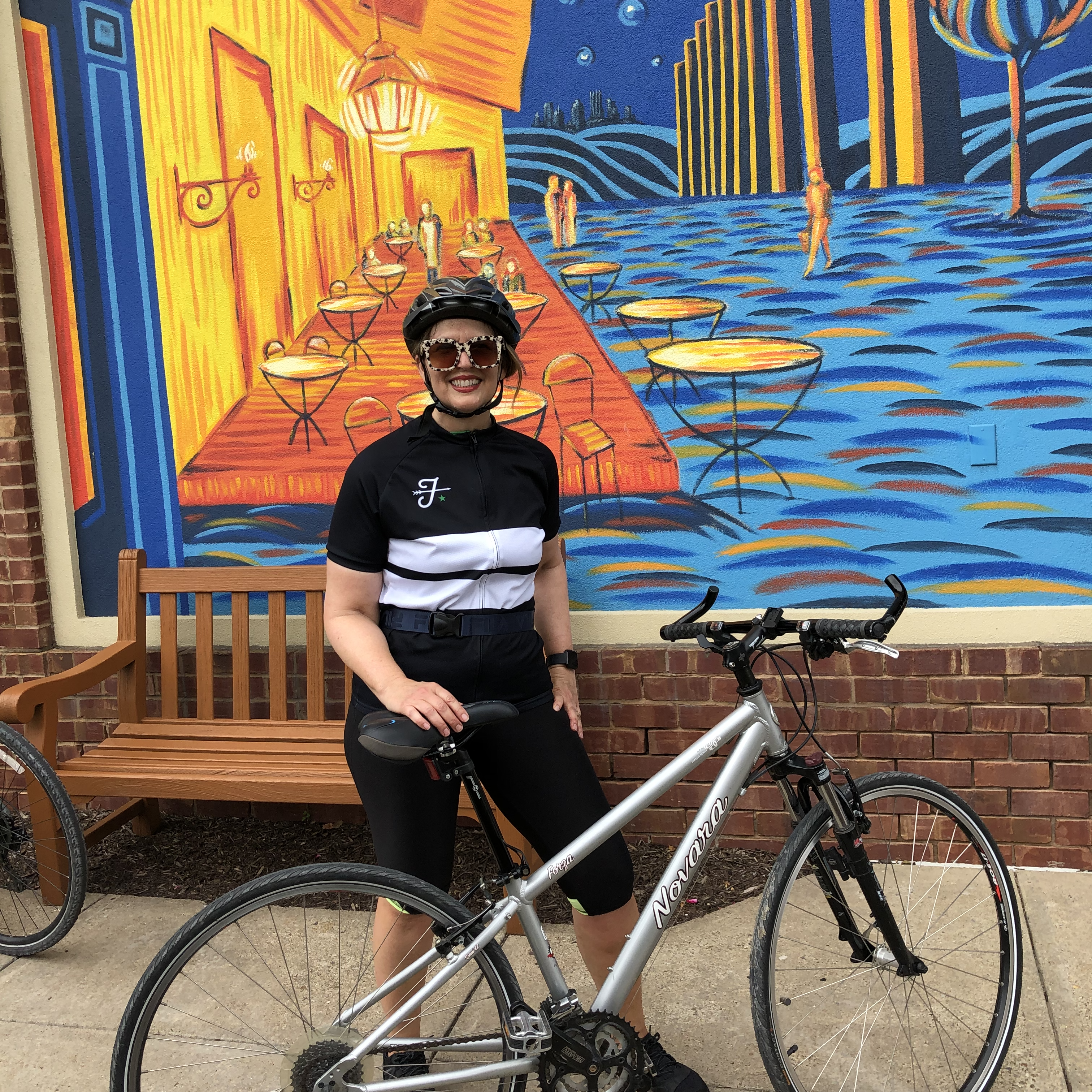 Photo of blogger in front of mural and behind a bicycle