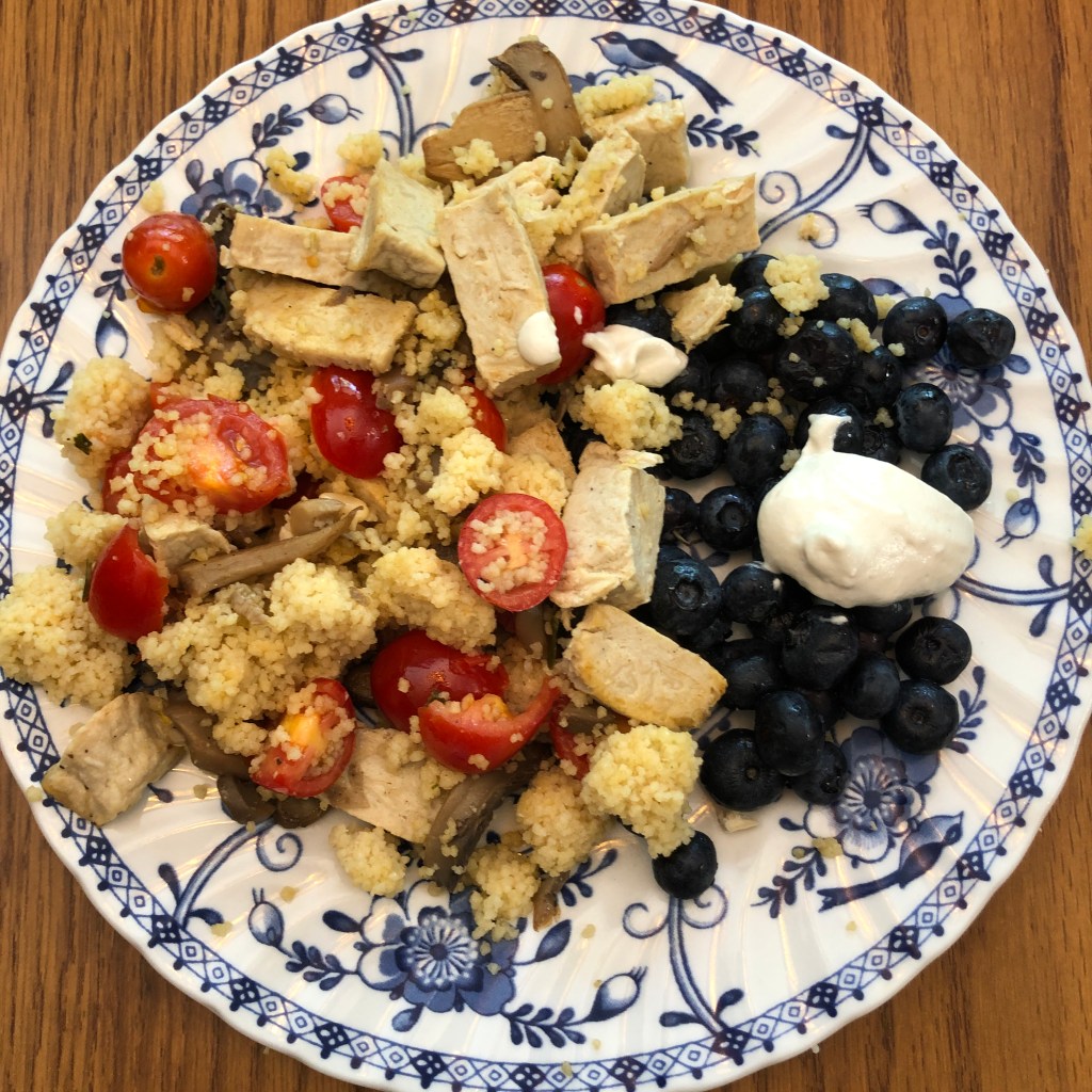 photo of plate with couscous dish and blueberries with cashew cream topping