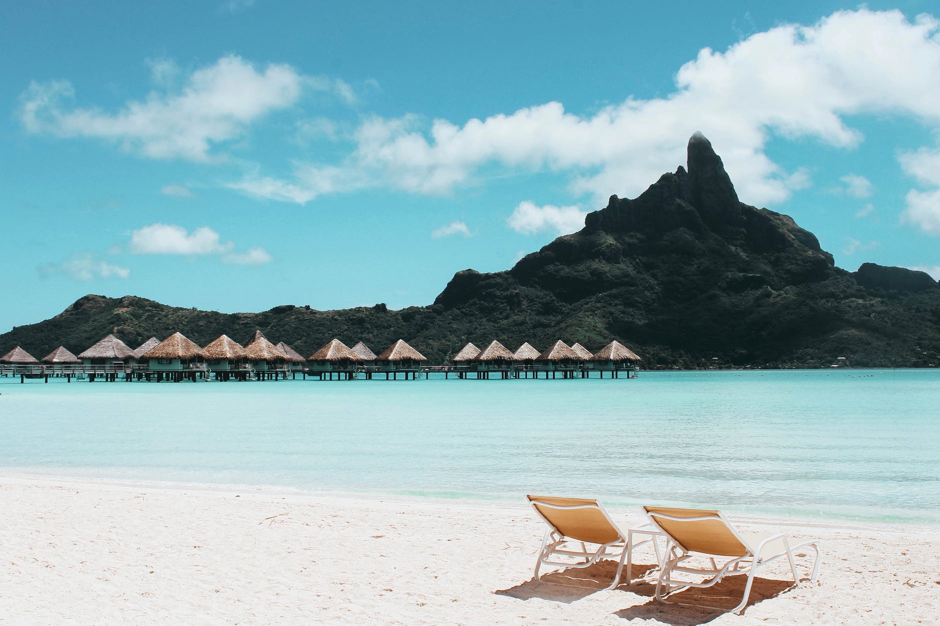 Image of beach with two empty lounge chairs