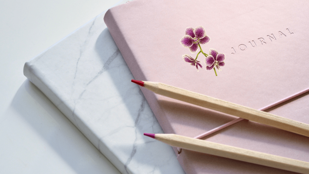 Image of journal books and 2 colored pencils