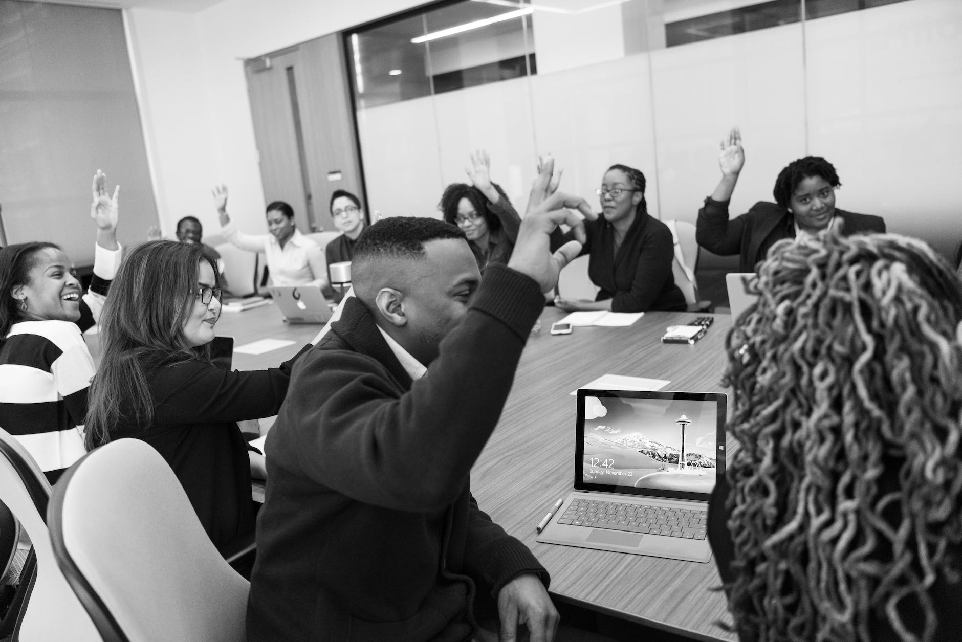black and white image of students in classroom setting with raised hands